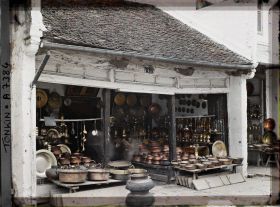 Image représentant Un étalage d'objets en cuivre (trépieds, vases...), à l'intérieur d'une boutique, dans la " rue du Cuivre "