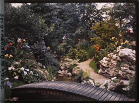 Image représentant Pont du " sanctuaire japonais " reliant un chemin bordé de roches à une rive fleurie