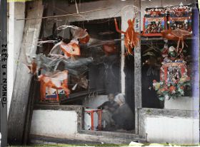 Image représentant Un étalage de jouets en papier huilé devant une boutique, dans la " rue du Chanvre "