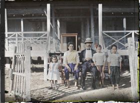 Image représentant Un fonctionnaire cambodgien et sa famille mêlant les styles de vêtements traditionnels (sampot) et occidentaux