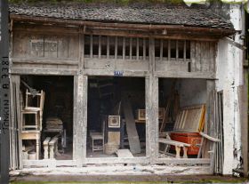 Image représentant Une boutique de cercueils et de mobilier en bois, dans la " rue des Cercueils "