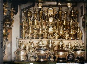 Image représentant Un étalage d'objets en cuivre (trépieds, vases...), à l'intérieur d'une boutique, dans la " rue du Cuivre "