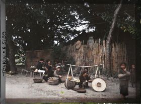 Image représentant Des marchands ambulants avec leurs palanches devant un restaurant en plein air