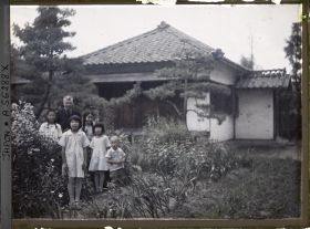 Image représentant Le père Cesselin, missionnaire français, entouré d'un groupe d'enfants vêtus à l'occidentale
