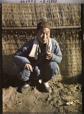 Image représentant Un ouvrier chinois assis, posant pour l'opérateur