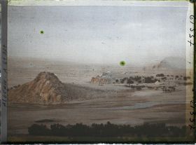 Image représentant Le lit de l'Oued Mzi avec à l'arrière-plan une tempête de sable