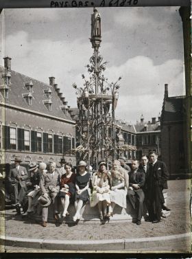 Image représentant Groupe de journalistes assis sur la margelle de la fontaine en fer forgé, érigée par Cuyper en 1836, portant la statue du comte Guillaume II par Jünger