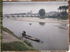 Image représentant Une barque typique de Loire amarrée, au second plan le pont Wilson et la cathédrale
