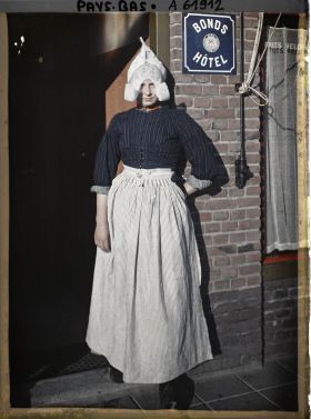 Image représentant Jeune fille en costume traditionnel à l'entrée d'un hôtel