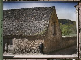 Image représentant Une maison dans le village avec un petit écolier belge devant