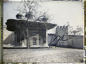 Image représentant Sultan Ahmet Ceshesi ("fontaine du Sultan Ahmet III") devant le mur du palais de Topkapi
