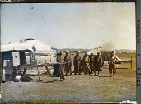 Image représentant Un groupe de lamas près de yourtes et de voitures dételées