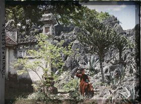 Image représentant Un jeune homme devant un temple environné de rochers et de cactées