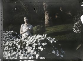 Image représentant La princesse Kitashirakawa, invitée par Albert Kahn, dans le jardin de sa villa, près d'un massif d'anthémis