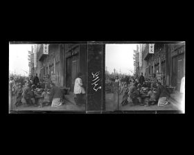 Image représentant Des hommes et des enfants attablés à un restaurant en plein air sur Dongsi pailou dajie ("avenue des Quatre Portiques de l'Est"), tronçon nord