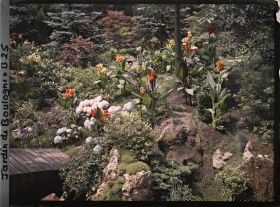 Image représentant Pont menant à une butte du " sanctuaire japonais " fleurie d'hortensias et de cannas