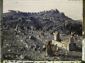 Image représentant Vers la ville surmontée de sa citadelle. Au premier plan, pierres tombales et l'un des cimetières entourant la ville