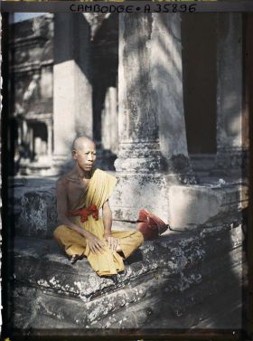 Image représentant Un bonze âgé, assis dans une galerie du préau cruciforme