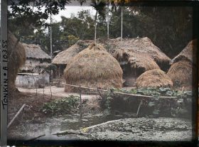 Image représentant Des meules de paille de riz et une mare recouverte de liseron d'eau dans un village