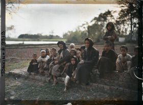 Image représentant Un groupe de villageois (principalement des enfants) assis devant le temple bouddhique, dit " Pagode de l'abattoir "
