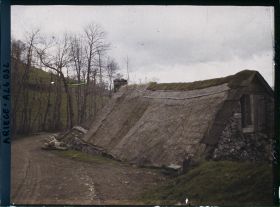 Image représentant Une maison couverte de chaume, avec de grandes plaques de schiste sur les bords