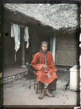 Image représentant Un notable de village en costume de cérémonie à l'occasion d'un mariage, assis dans une cour intérieure
