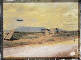 Image représentant Des marchands ou des petits restaurants en plein air, installés sous des abris de paille, au bord du chemin