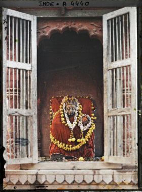 Image représentant Statue représentant Shiva et son épouse Parvati, drapée d'une étoffe rouge et ornée de guirlandes de fleurs dans le temple de Kashi Vishvanath (Temple d'or)
