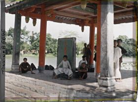 Image représentant Un groupe d'enfants sous le Thui-toa " Kiosque du bord de l'eau ", abritant une stèle de pierre nommée " Tablette du Temple de Van-xu'o'ng "