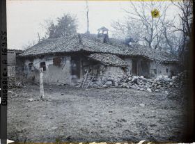 Image représentant Une ferme à toit de tuiles, murets en pierre et tas de petits bois