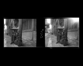 Image représentant Yonghegong ("palais de l'Harmonie et de la Concorde"). Dans la deuxième cour, un moine assis près d'un moulin à prières, sous la galerie à colonnes de bois de Mizongdian ou Çanitedian ("pavillon de la Doctrine Ésotérique ou de l'École de l'Explication de la Doctrine")