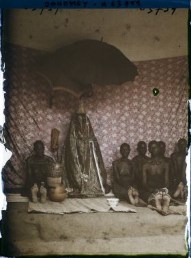 Image représentant Sacrifice à la tête : femmes du roi Houdji entourant les insignes de la royauté à l'occasion de la séparation du crâne du roi défunt de son corps