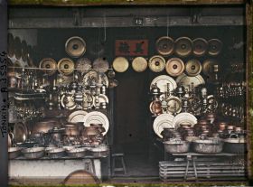 Image représentant Une boutique d'objets en cuivre (ustensiles de cuisine, plateaux...), au numéro 12 de la " rue du Cuivre "
