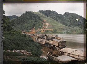 Image représentant Des sampans ancrés au bord de la rivière Claire, à l'arrière-plan, les mines de zinc de Trang-da