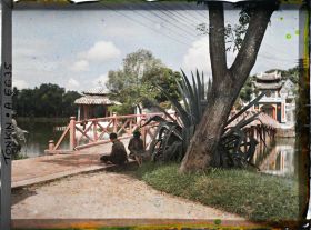 Image représentant Des mendiants à l'entrée de la passerelle reliant le temple Ngoc-so'n (appelé par les Européens "Pagode des Pinceaux"), situé sur "l'île de Jade" du Petit Lac, au rivage