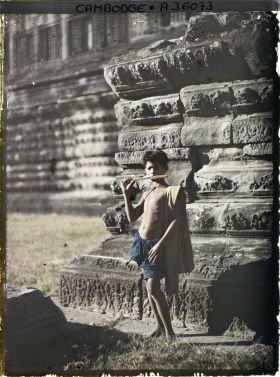 Image représentant Un jeune joueur de flûte, au pied de la galerie pourtournante formant le deuxième niveau du temple