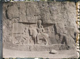 Image représentant Bas-relief sassanide sous le tombeau de Darius. Scène de triomphe de Shapur 1er sur Philippe L'Arabe, agenouillé et sur l'empereur romain Valérien qui remet ses armes au vainqueur monté sur son cheval (fin IIIe siècle)