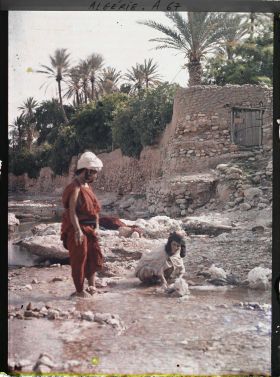 Image représentant Deux femmes, appartenant probablement à la tribu des Ouled Naïl, au bord de l'oued