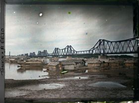 Image représentant Des maisons flottantes sur Fleuve Rouge, près du pont Doumer, au coucher du soleil