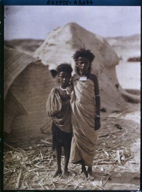 Image représentant Deux enfants  null bishari posent pour l'opérateur devant des habitations