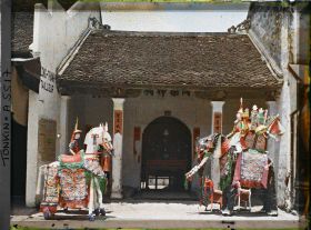 Image représentant Une exposition d'objets votifs en papier devant un petit temple du quartier sino-annamite