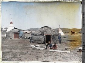 Image représentant Deux jeunes Mongols assis devant une yourte