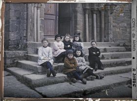 Image représentant Groupe de petites filles assises devant l'église de la Trinité de Brélévenez
