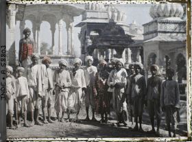 Image représentant Groupe de paysans entourant un rajpoute en costume de marié devant les chatris de la nécropole des Maharanas du Mewar