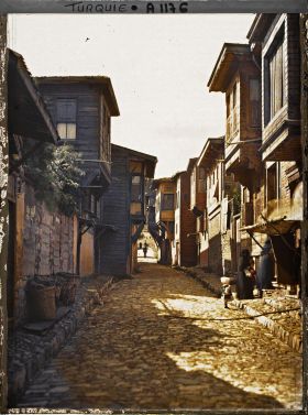 Image représentant Une rue pavée d'Eyüp bordée de maisons en bois à étages saillants