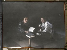 Image représentant Deux étudiantes à leur table de travail