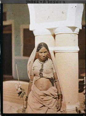 Image représentant Portrait en plan américain d'une femme à l'entrée d'une maison
