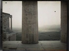 Image représentant Sur l'Acropole, au premier plan, une colonne de Propylées de Mnesicles et au fond, le Temple d'Athéna Nike, les environs et la mer