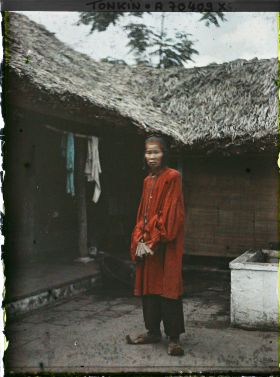Image représentant Un notable de village en costume de cérémonie à l'occasion d'un mariage, assis dans une cour intérieure
