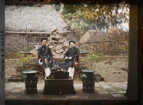 Image représentant Un lettré en costume de fête et un notable, assis dans la cour intérieure d'une habitation